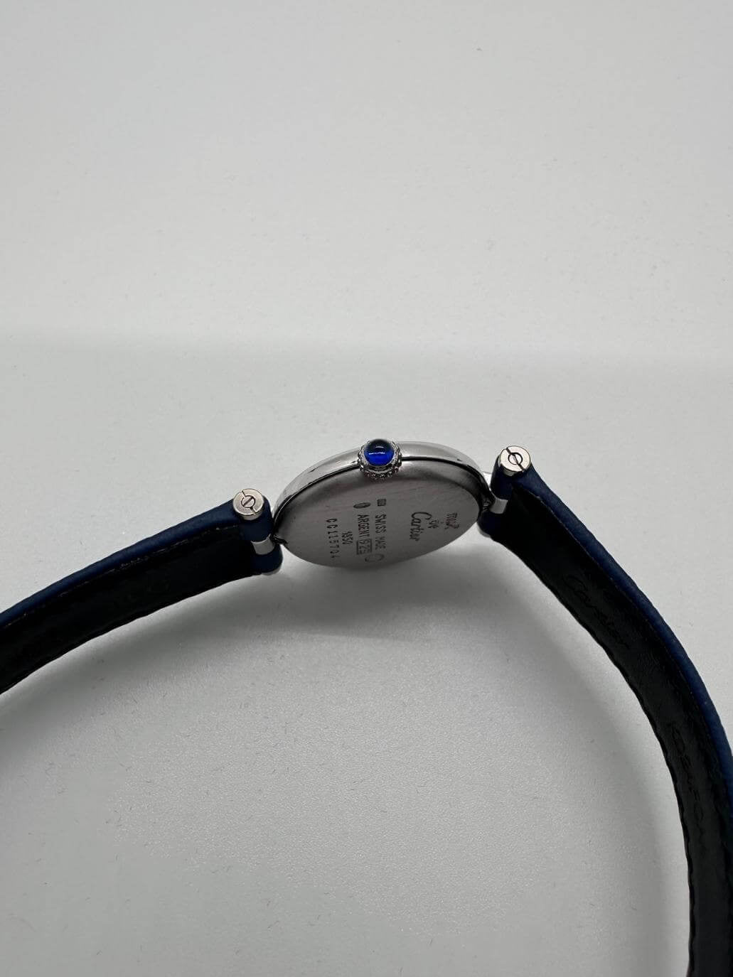 Detail of crown of Cartier watch on a white background