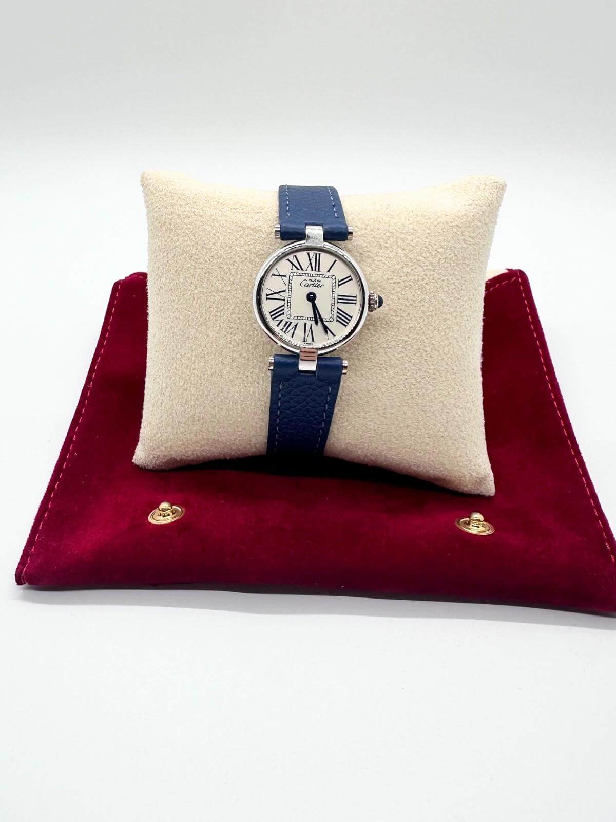 Cartier Vendome watch on pillow on red fabric travel pouch on white background