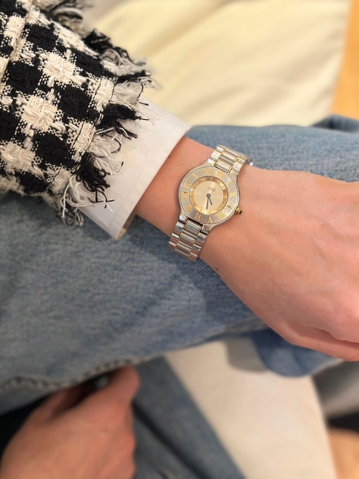Model wearing Cartier must watch in stainless silver and gold round dial.