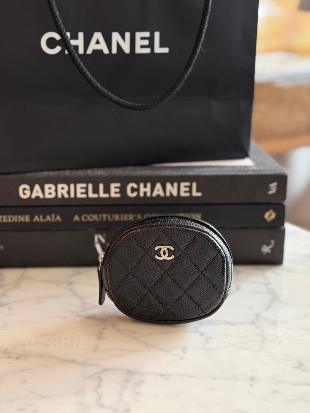 Louise Row featuring Chanel cavier coin purse on table