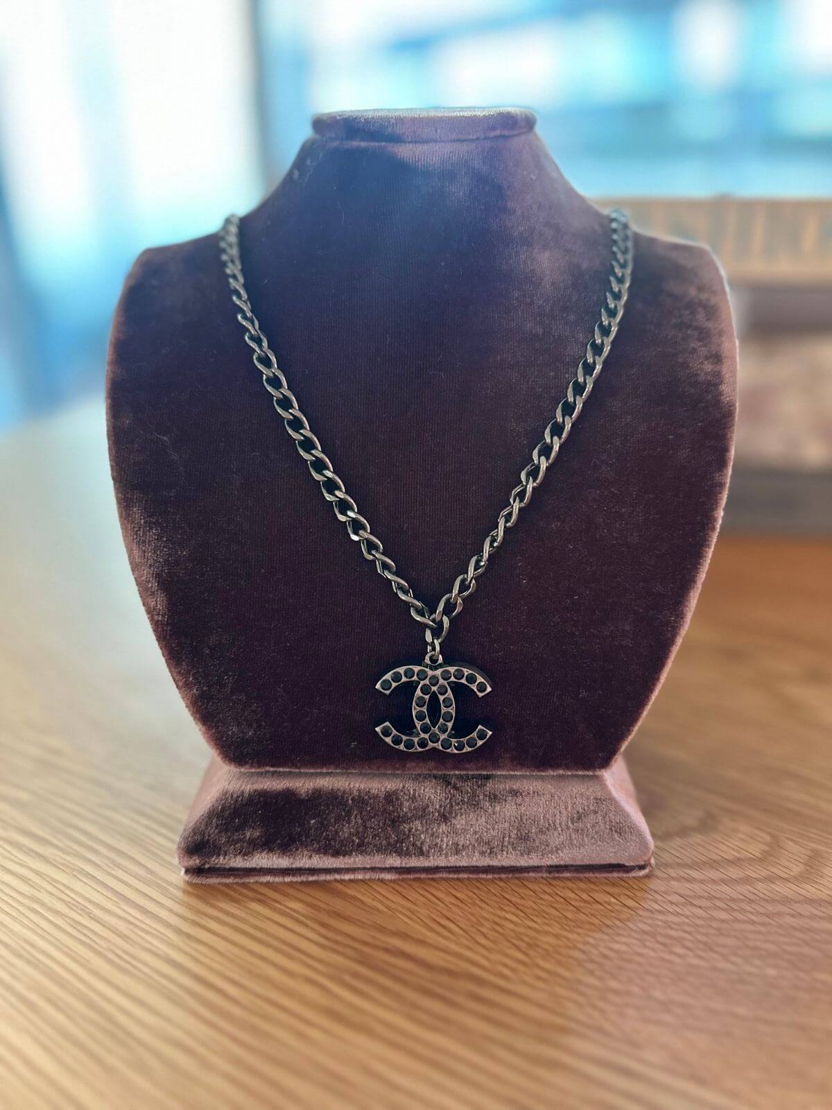 Chanel necklace on brown fixture