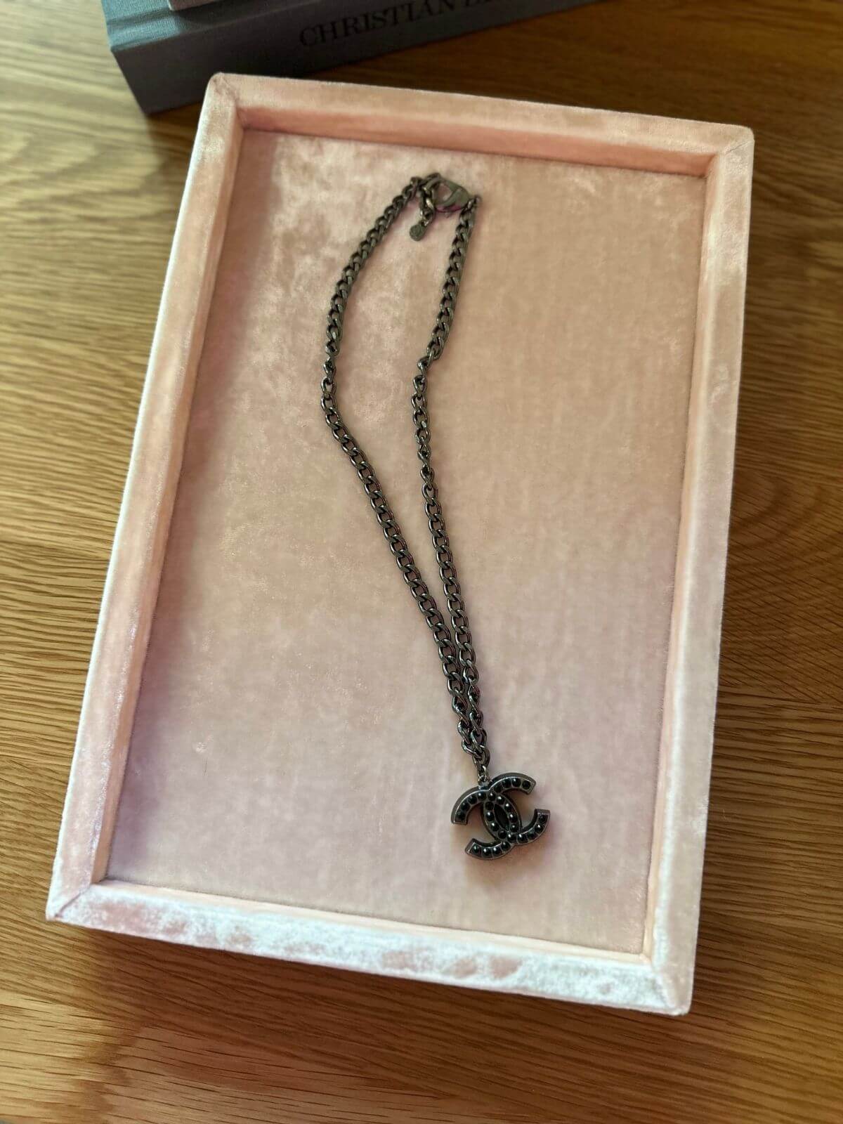 Chanel necklace on pink display