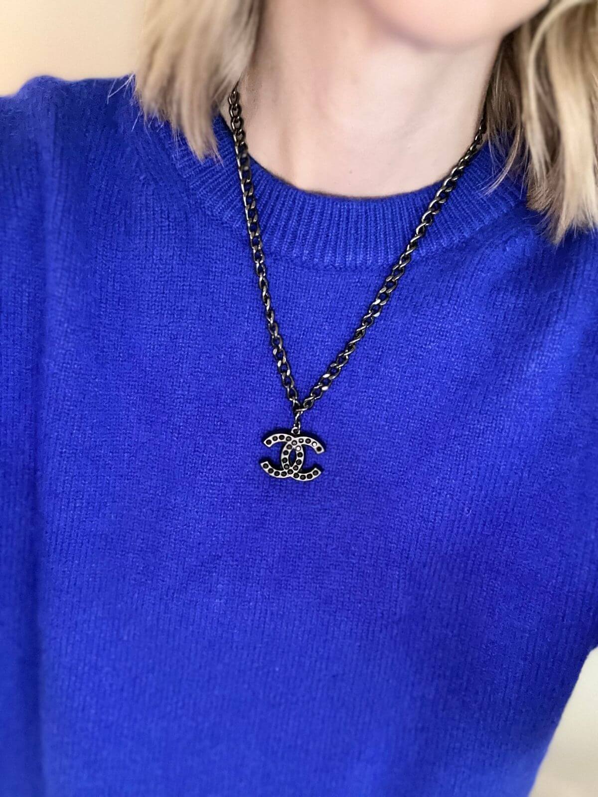 Chanel necklace on model in blue sweater