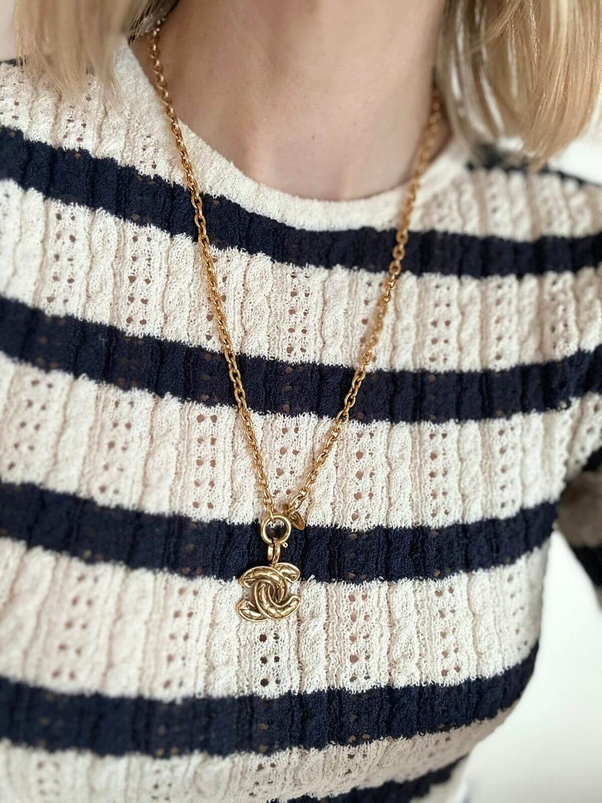 Chanel Logo necklace on model in striped shirt