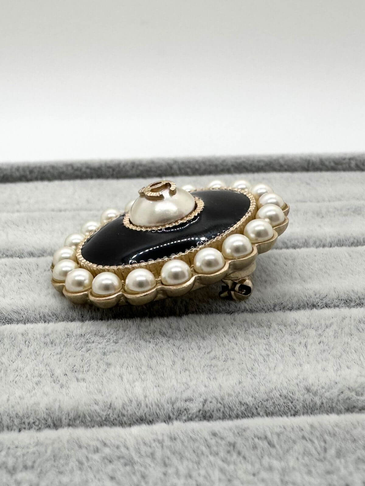 Chanel Oval brooch on grey background side view