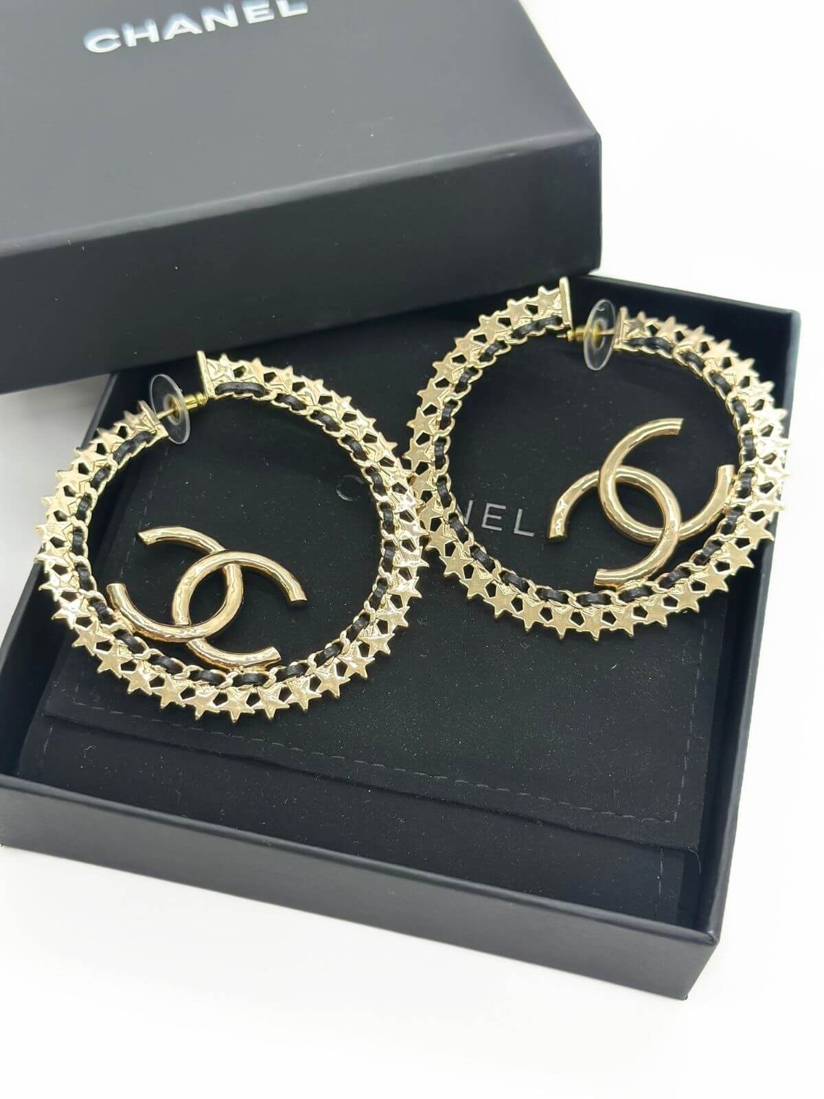Chanel star hoop earring in black box.