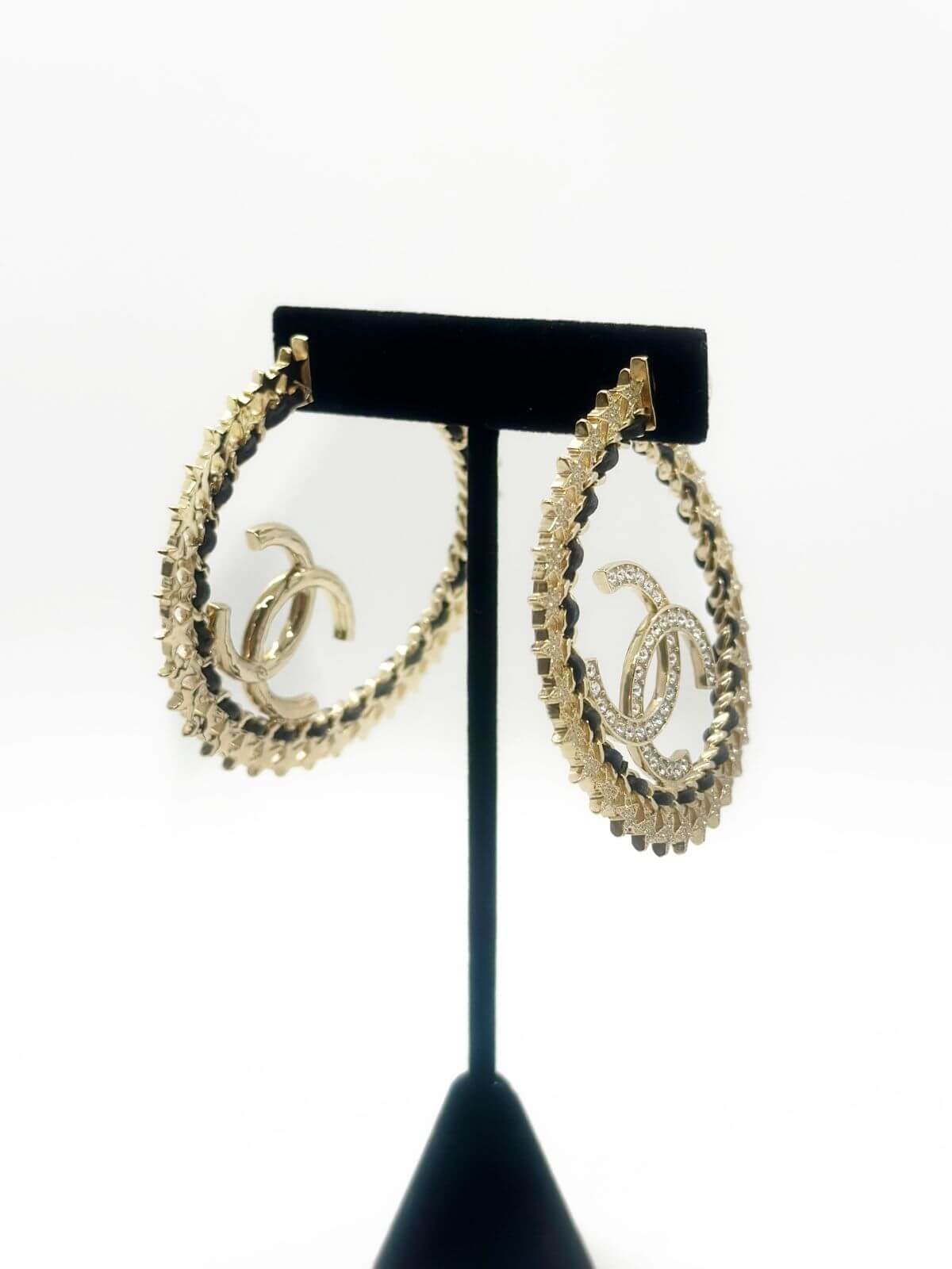 Chanel star hoop earring on fixture on white background.