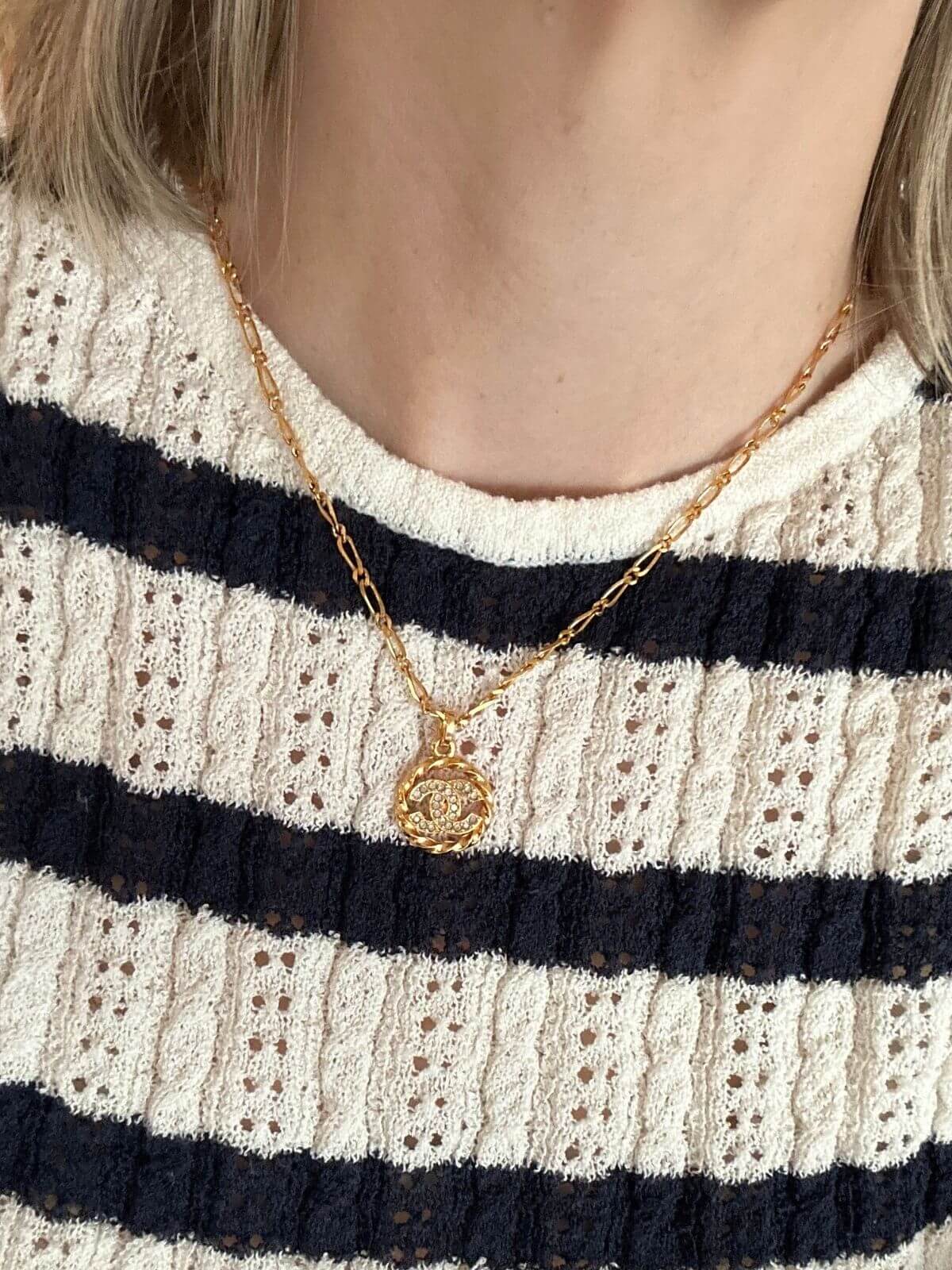 Chanel Logo necklace on model in striped shirt