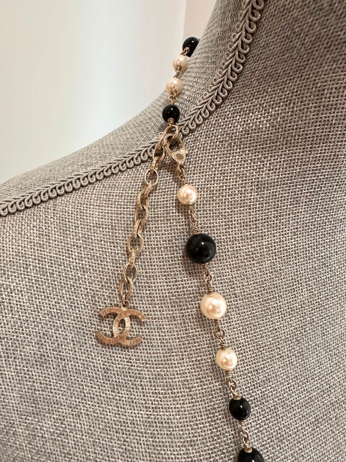 Louise Row featuring Chanel black and white beaded necklace on grey mannequin