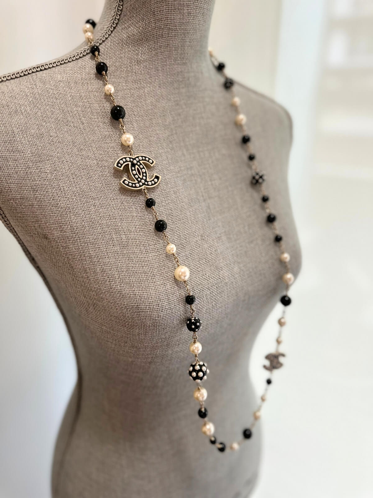 Louise Row featuring Chanel black and white beaded necklace on grey mannequin