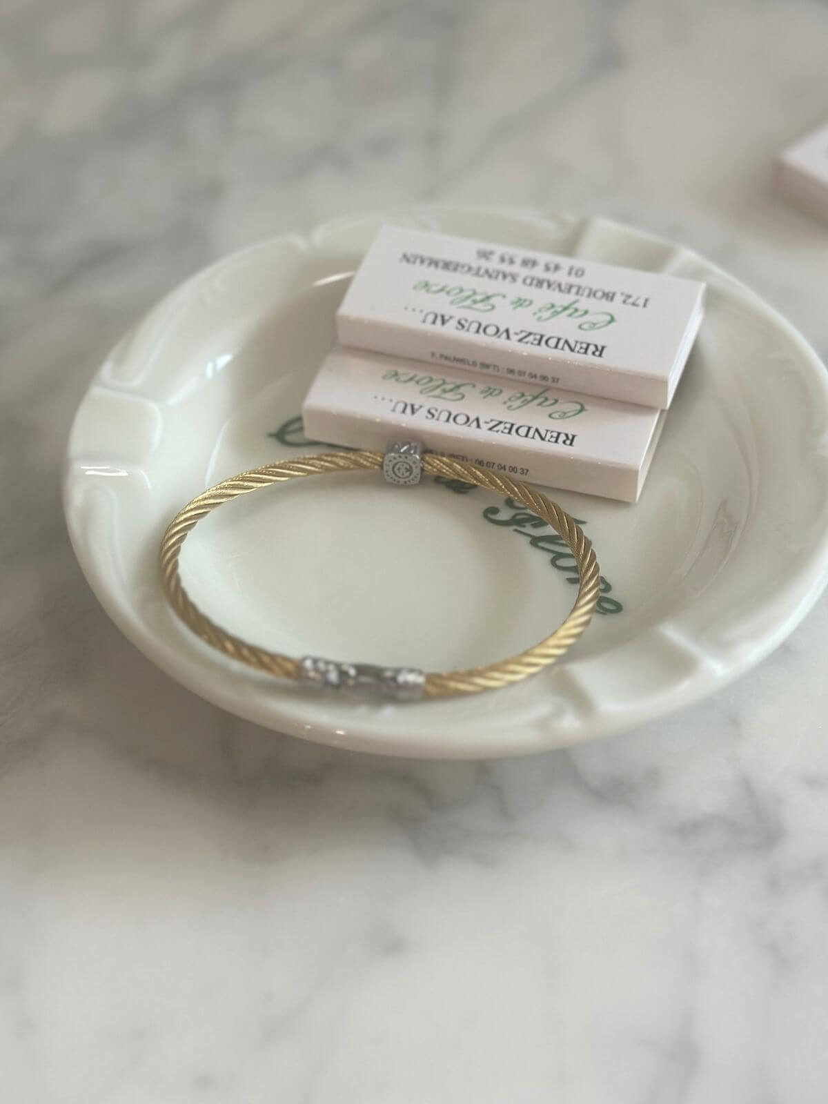 Louise Row Studio featuring Charriol cable bracelet on plate on grey table. Showing signature on back side station.