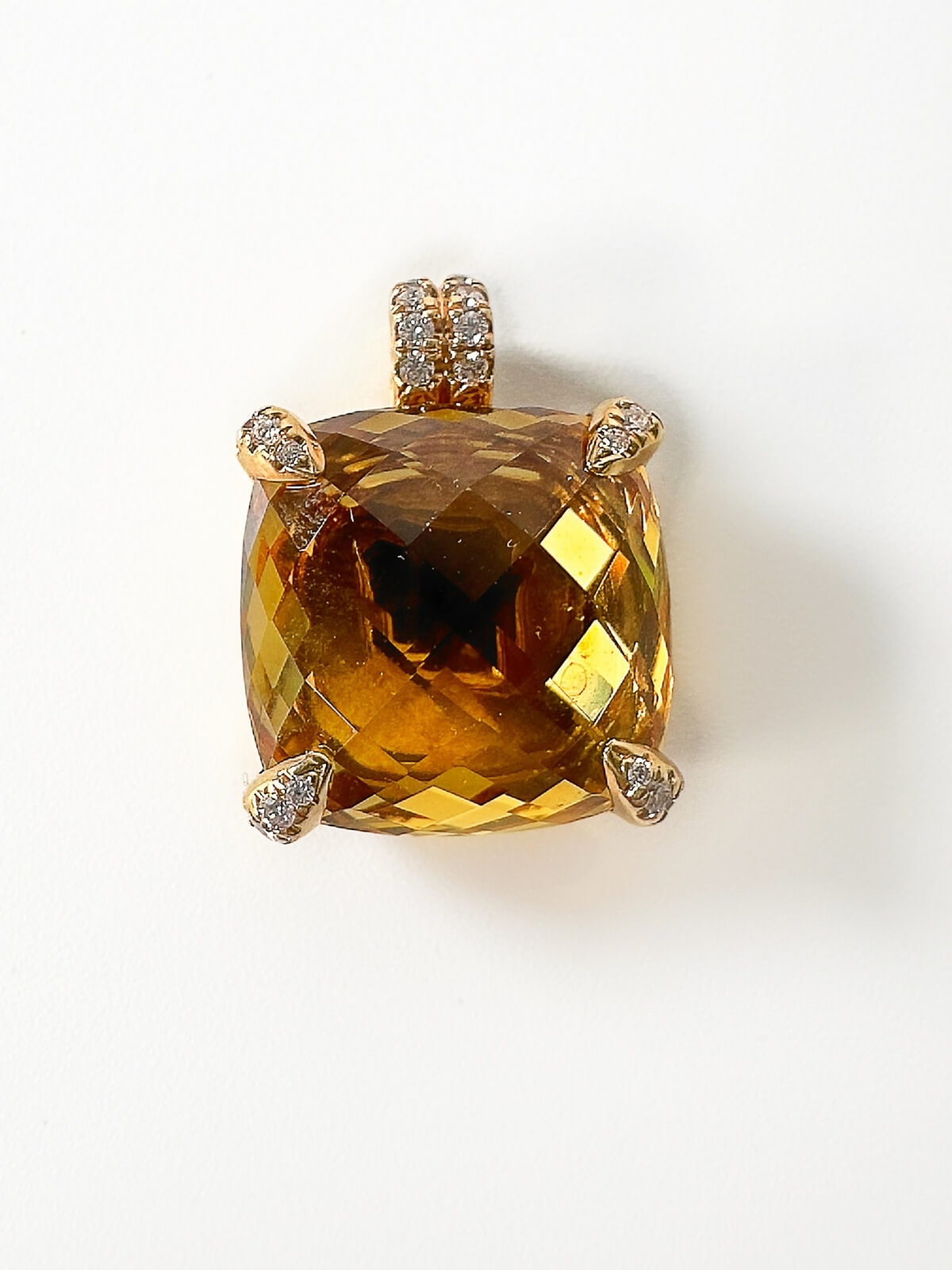 Gold pendant with prong settings set with diamonds with a Citrine gemstone on a white background