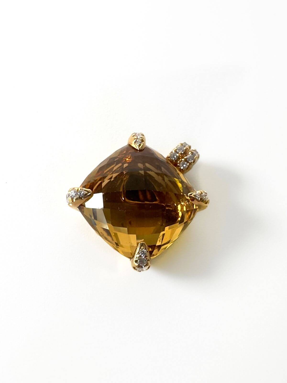 Gold pendant with prong settings set with diamonds with a Citrine gemstone on a white background