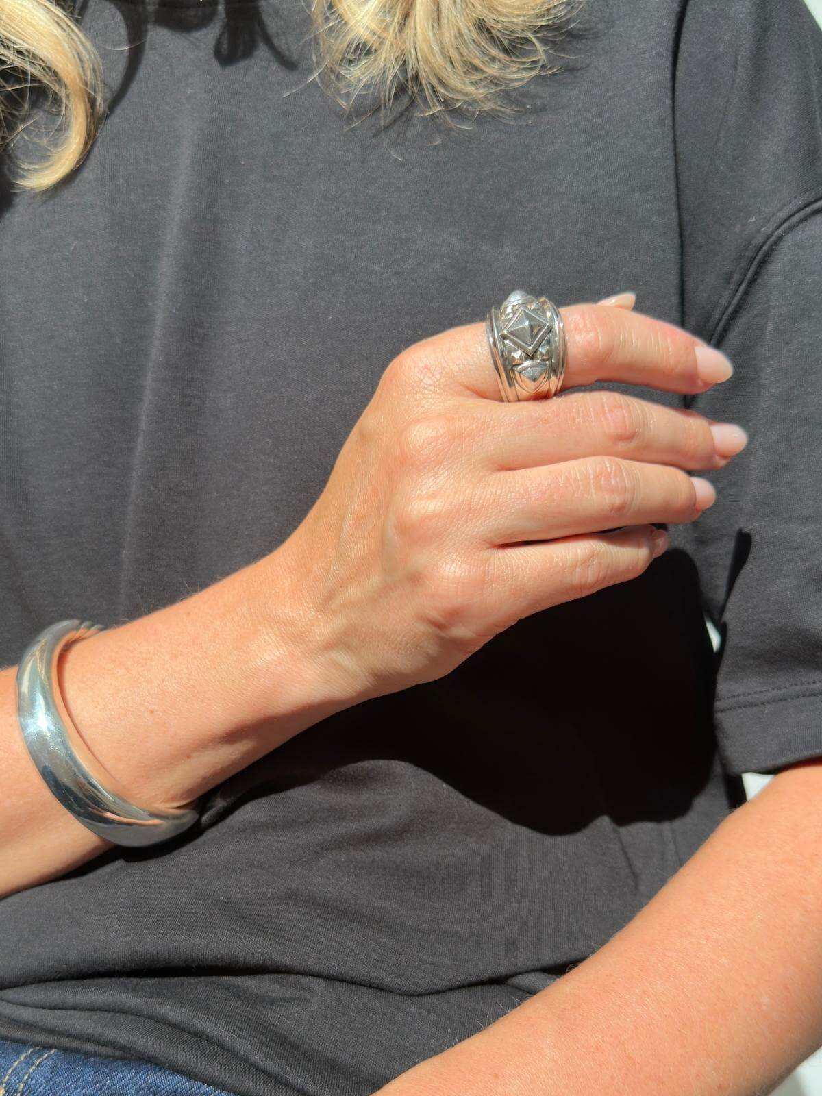 Close up of model in t shirt with silver ring on finger