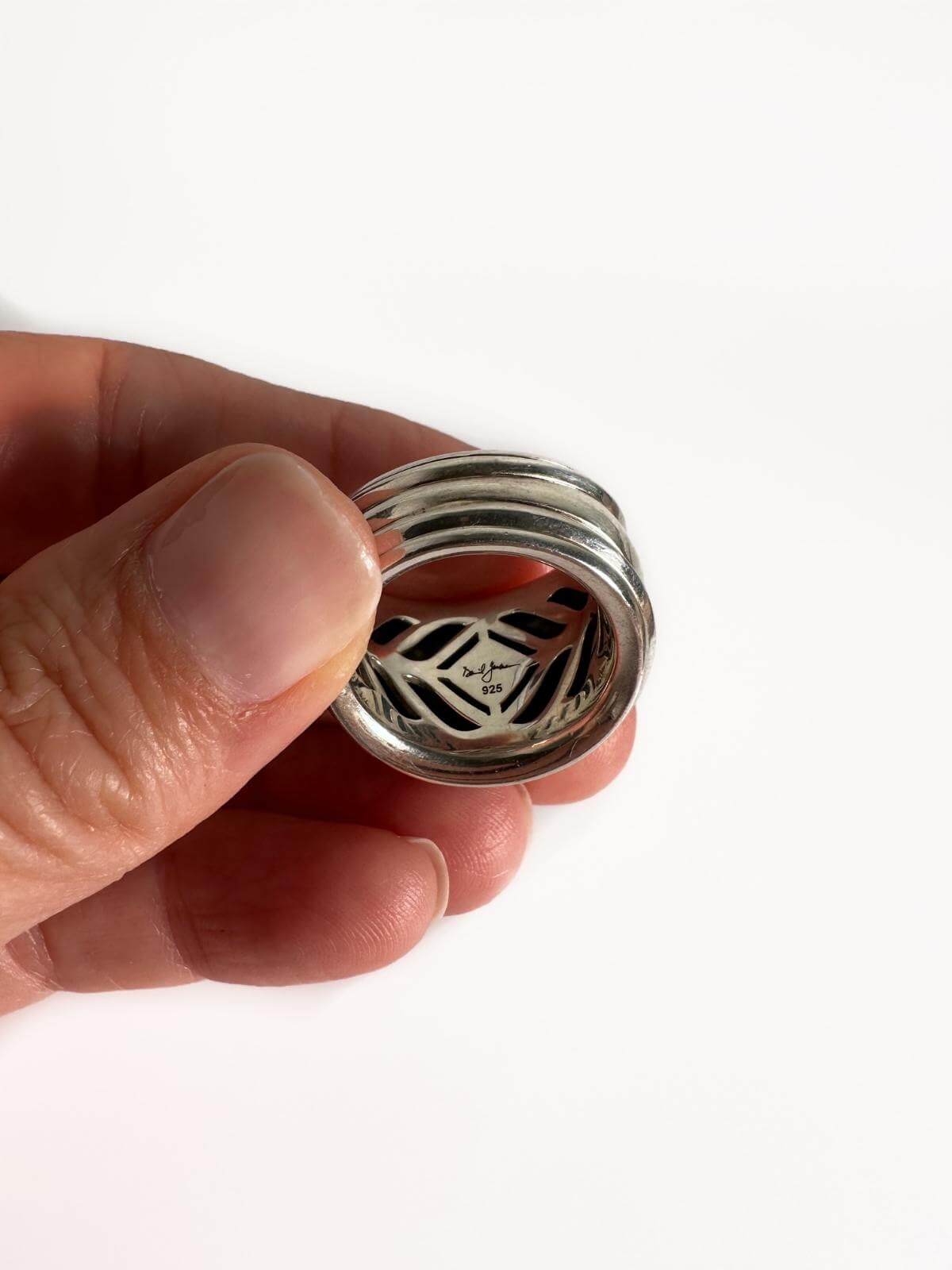 DY Silver Ring held by hand showing signature on inside of ring