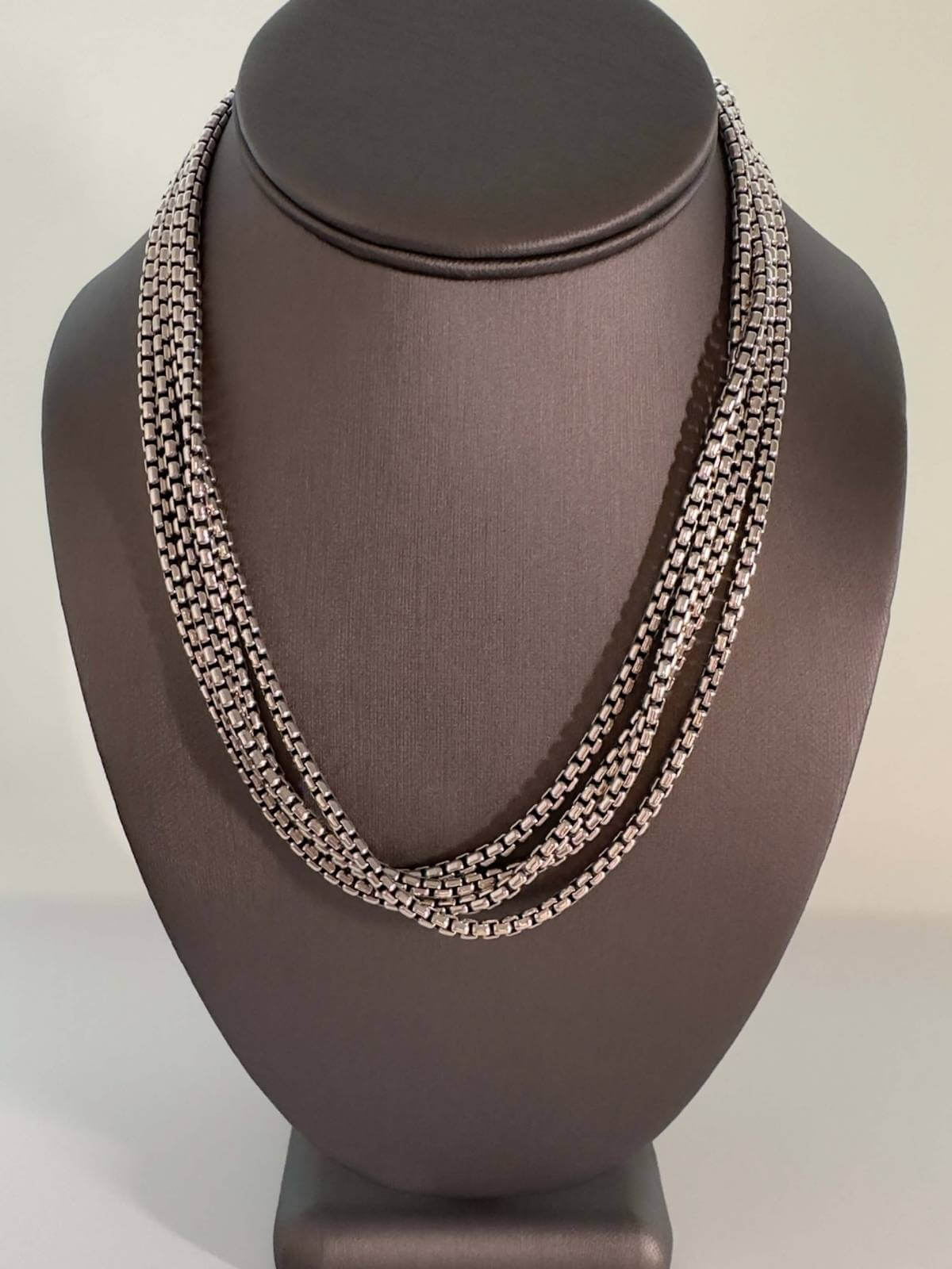 Silver DY 72" chain necklace on a dark brown mannequin bust against a neutral background