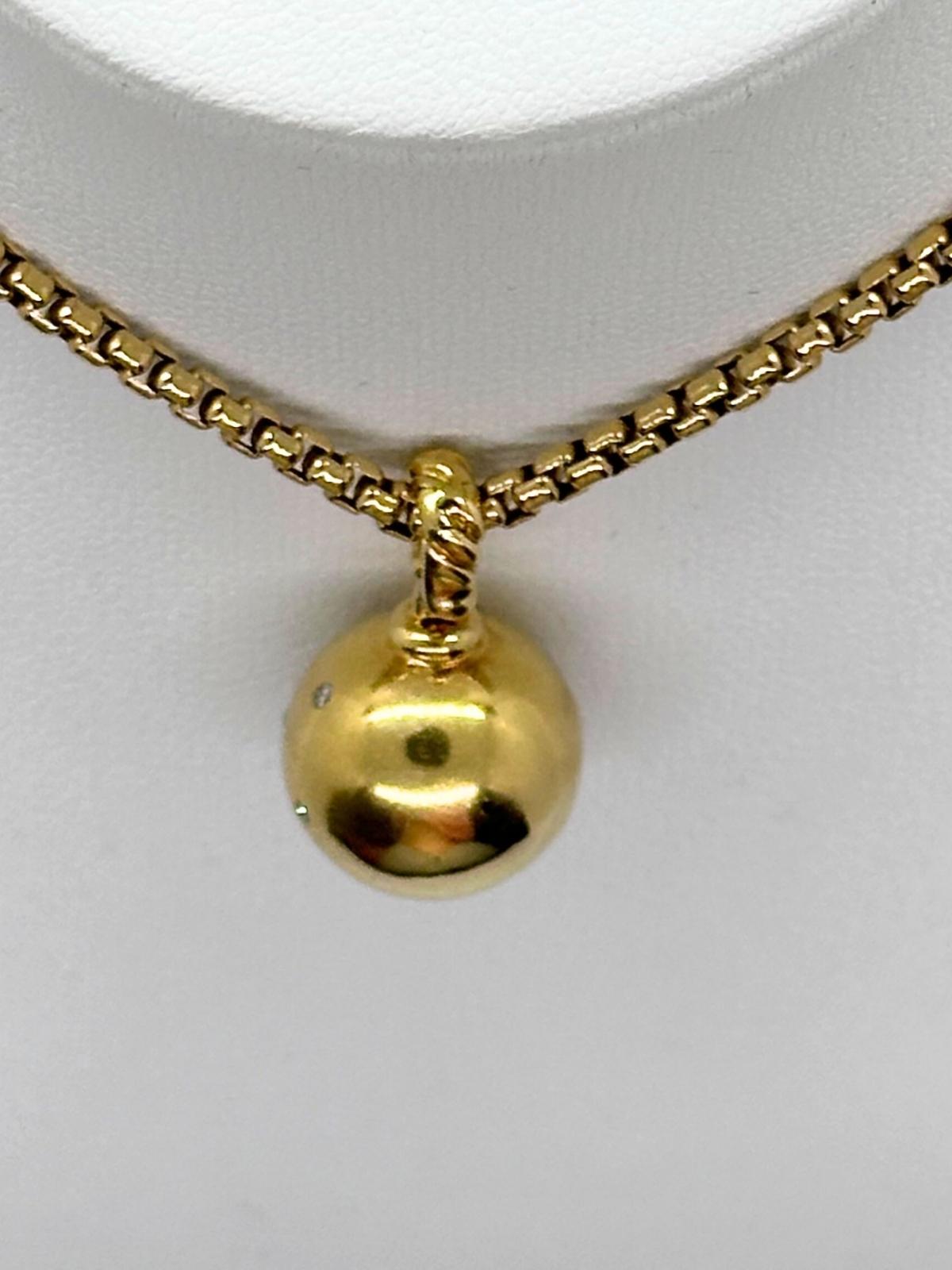 Back of pendant shown, Gold necklace with a round pendant on a white background