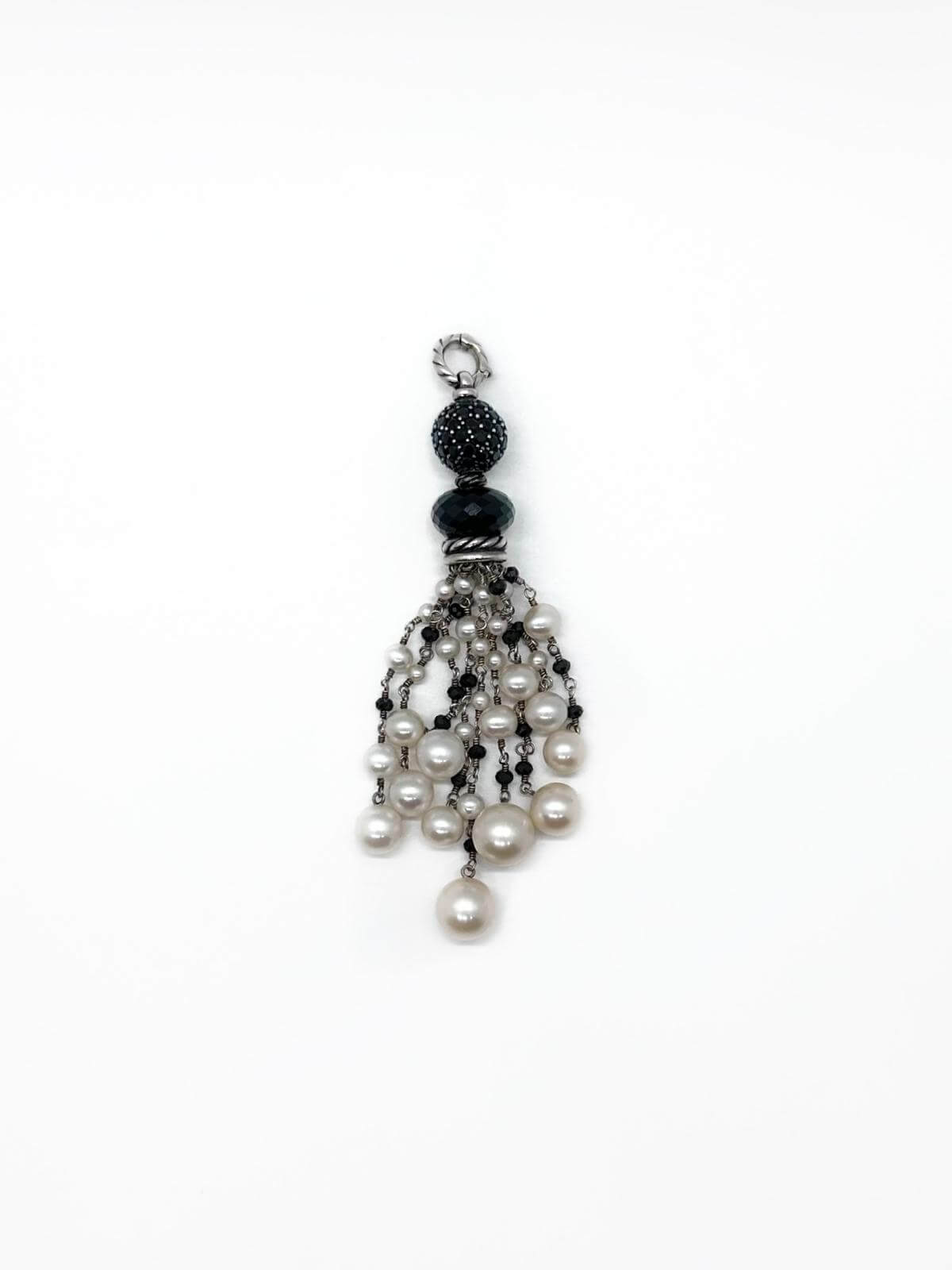 Pearl and black bead pendant on a white background