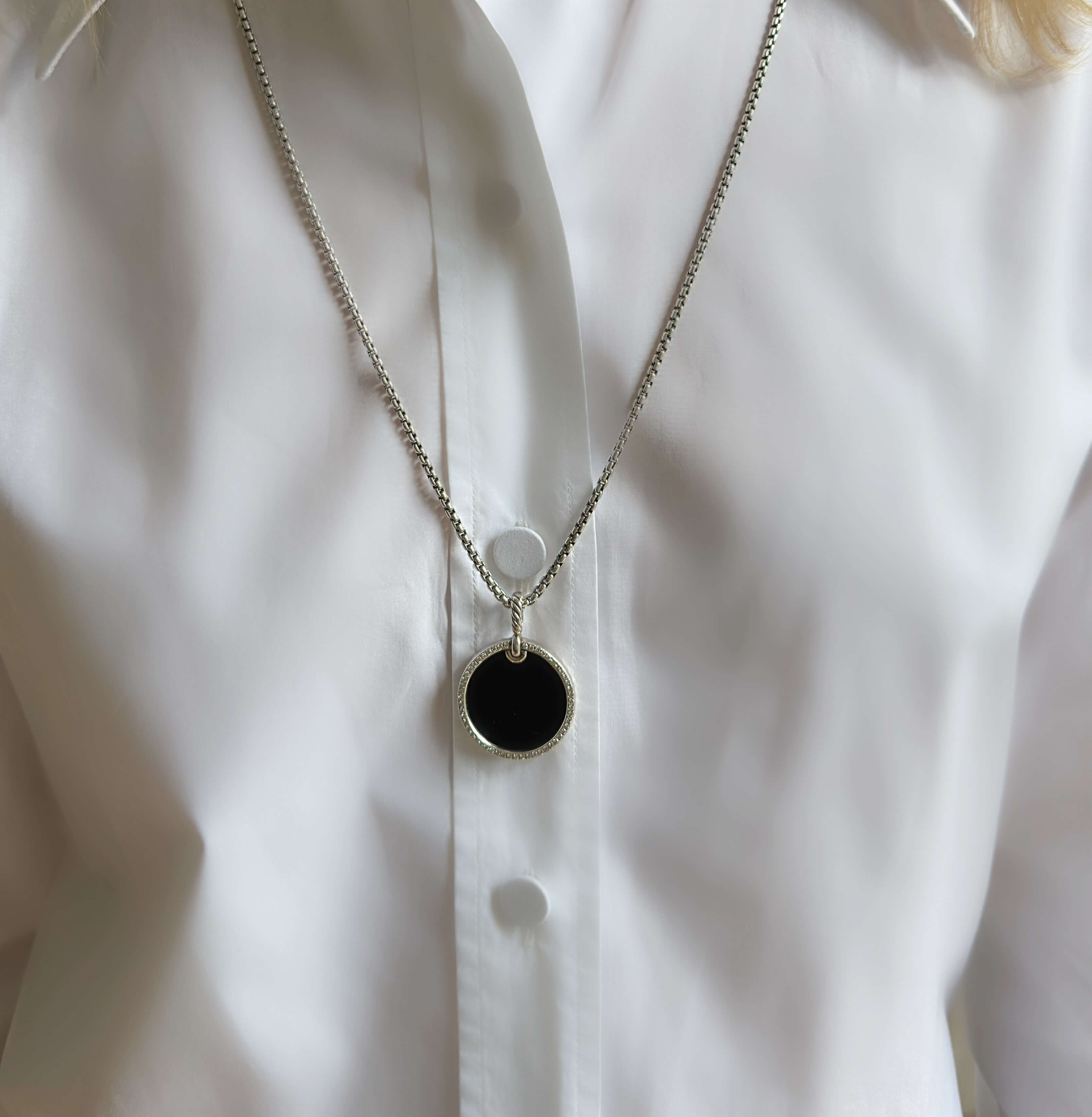 DY Necklace with a black pendant on a white shirt