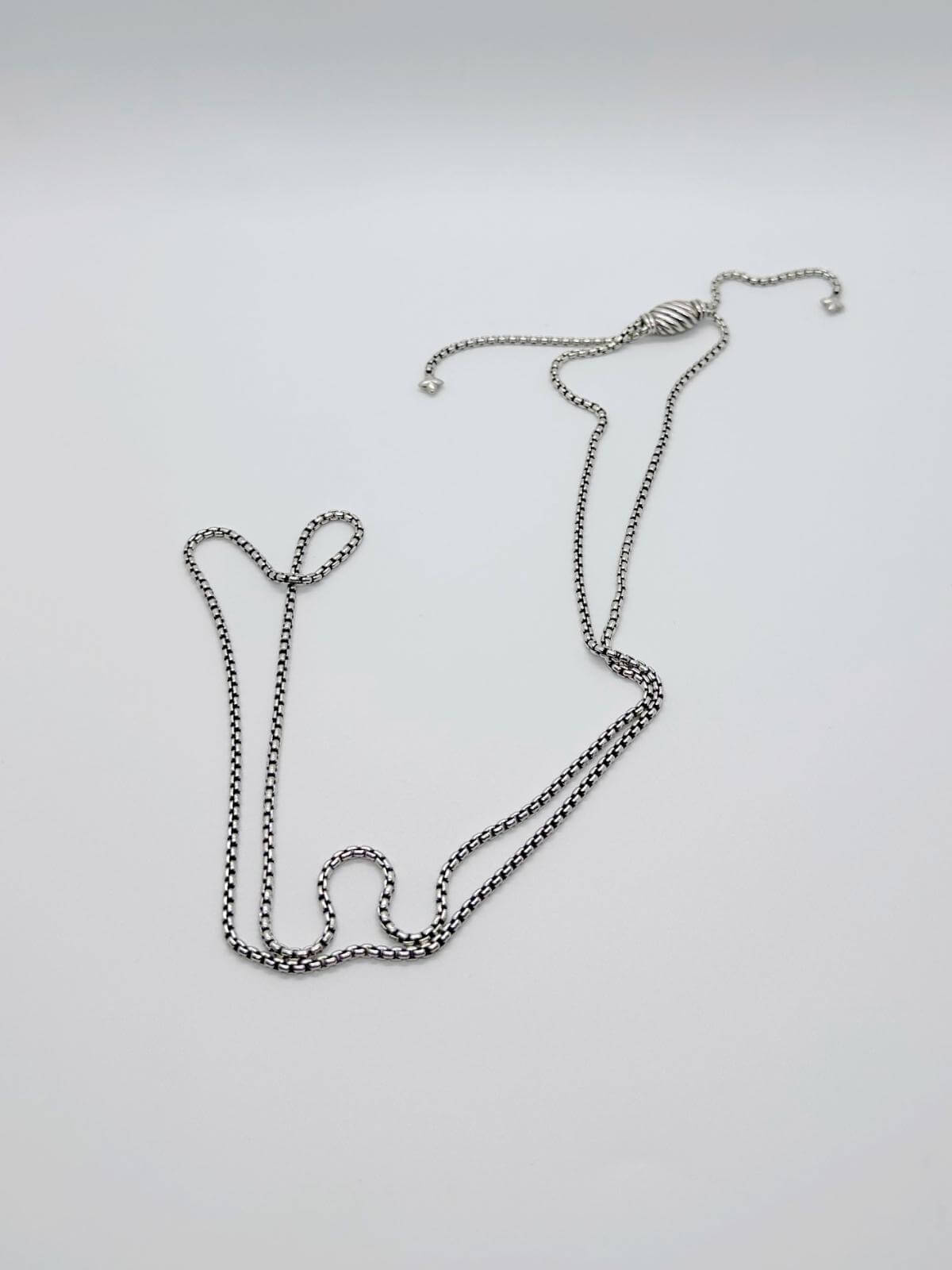 Long picture of David Yurman Silver chain necklace on a light gray background