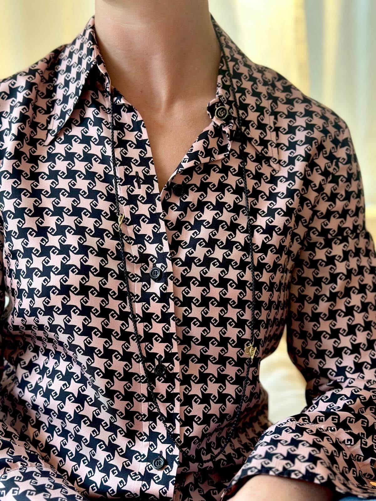 Model in checkered shirt wearing DY long black chain with gold medalions.