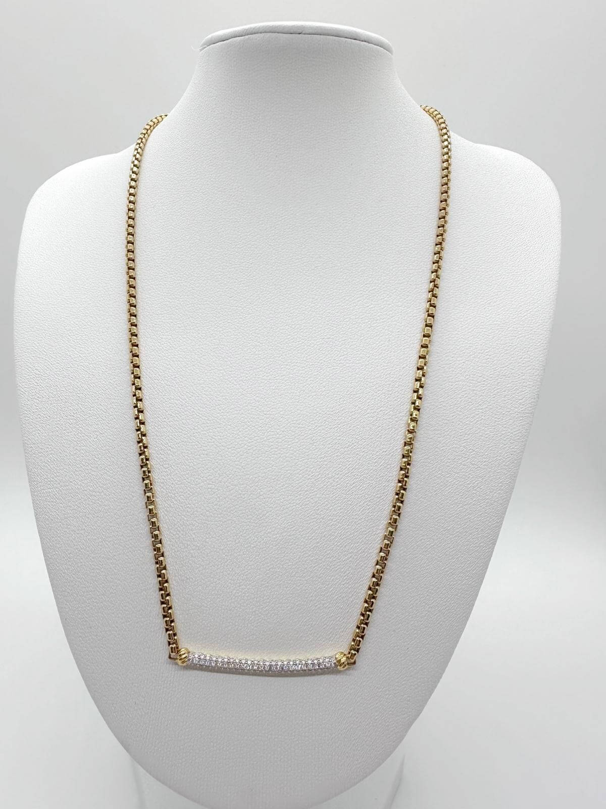 DY diamond bar on Gold chain necklace on a white mannequin bust against a white background