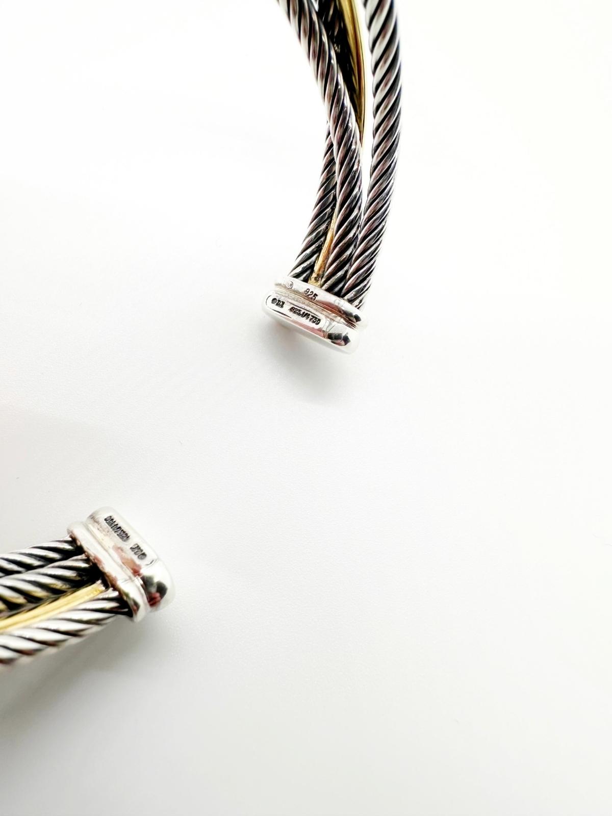 David Yurman Crossover cuff in gold and silver on white background detail of signature showing DY and gold and silver stamp.