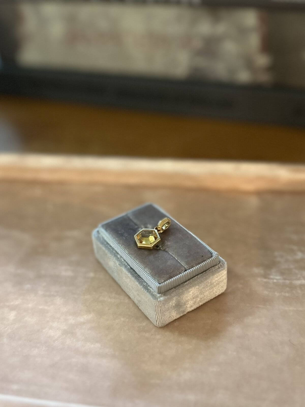 David Yurman Gold necklace with a hexagonal pendant on a pink fixture