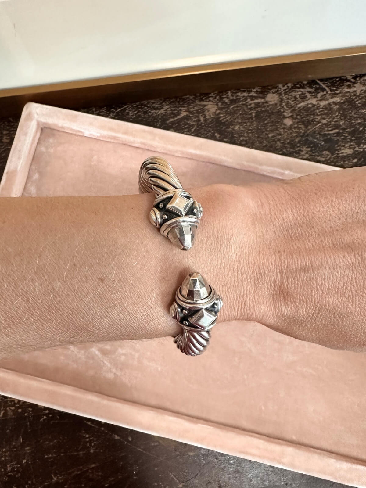 Louise Row featuring David Yurman Renaissance Bracelet in silver on pink pad on wrist of model