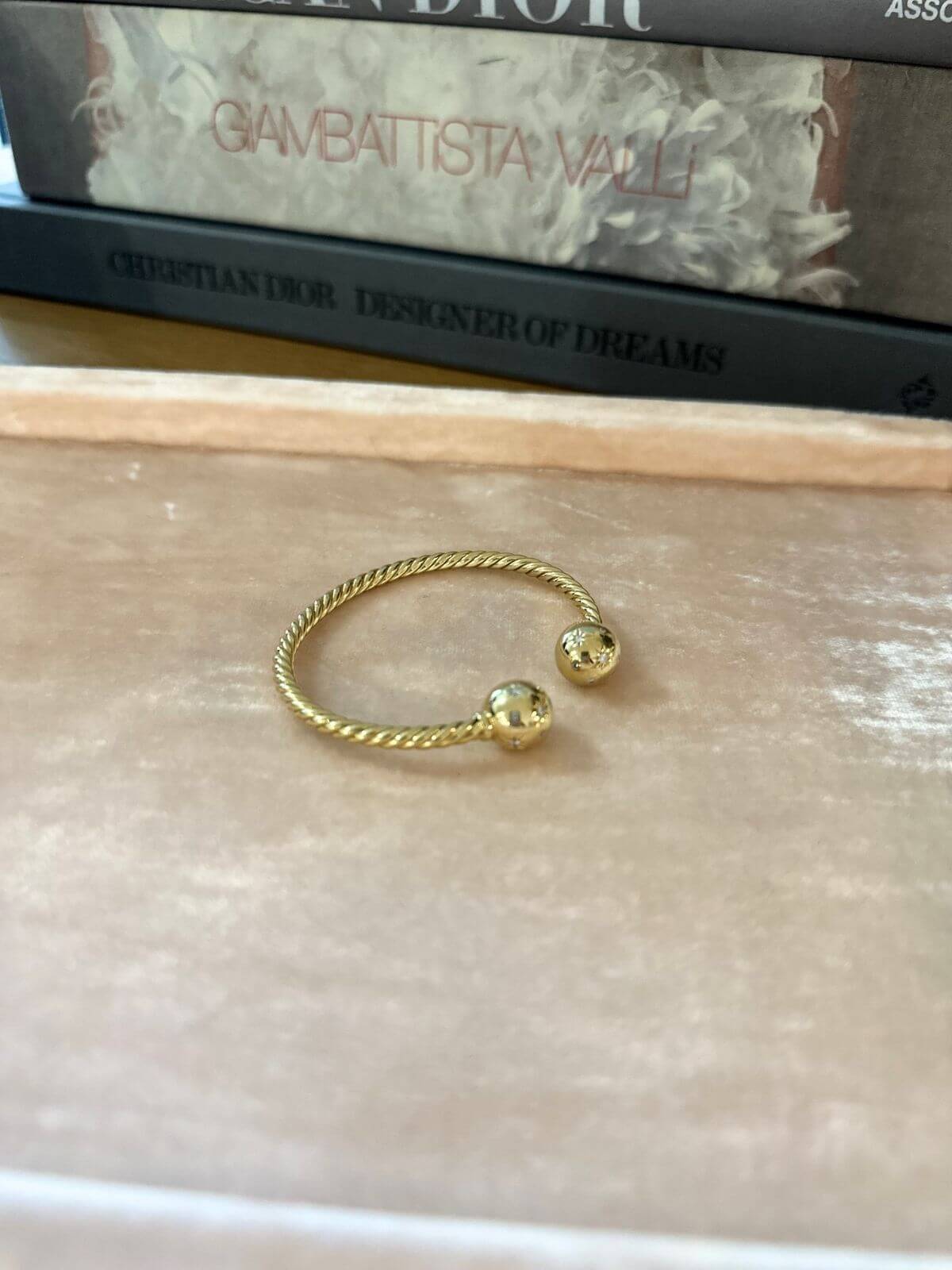 Gold David Yurman Solari bracelet on pink tray