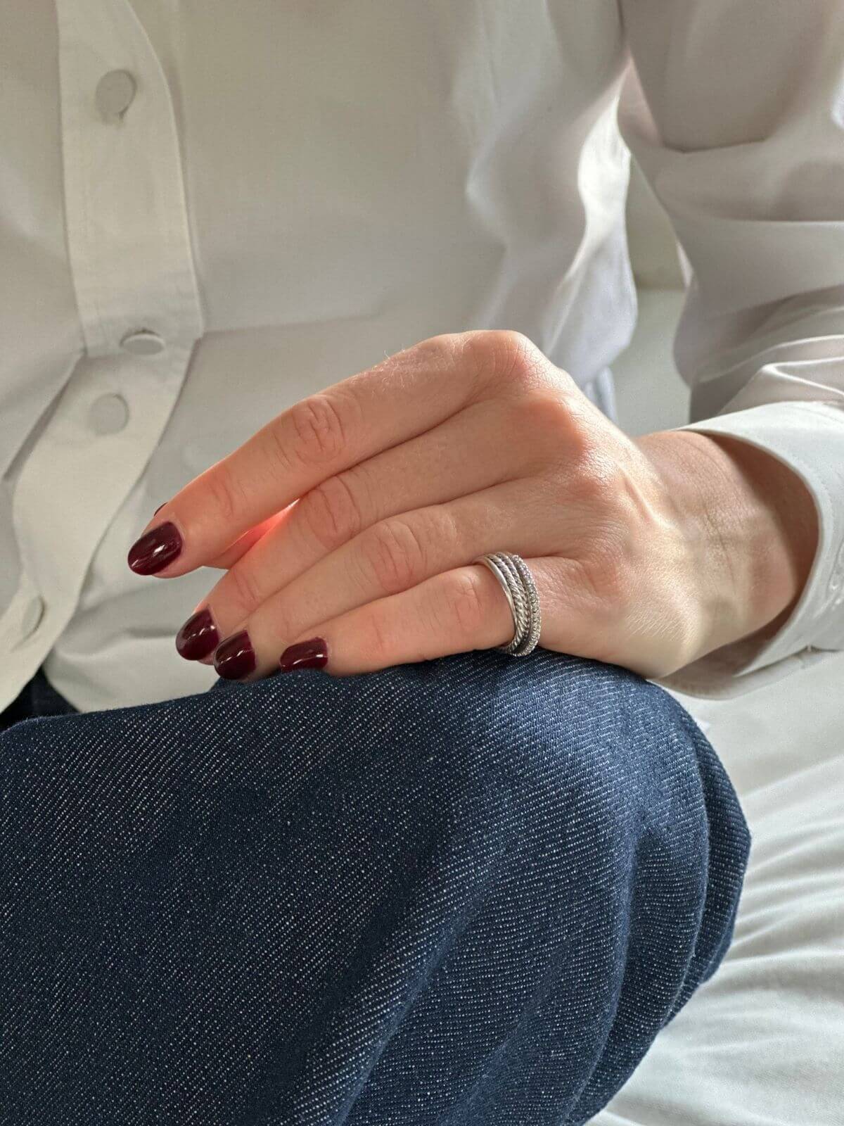 David Yurman silver Crossover ring on pinky finger of model with hand on jeans