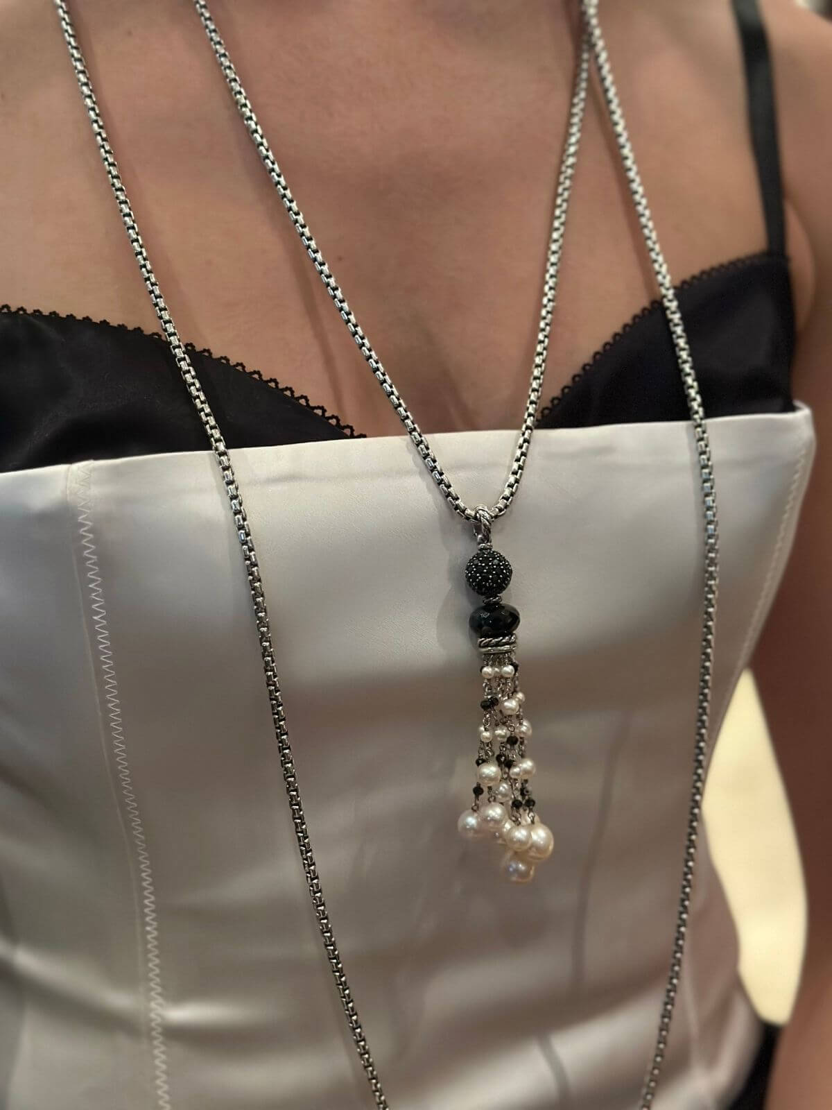 Necklace with black bead and pearl pendants on a white background