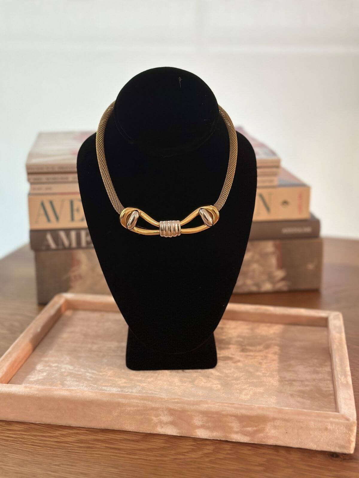 Louise Row Studio Vintage Givenchy necklace of gold 2 tone bow design on black neck form.