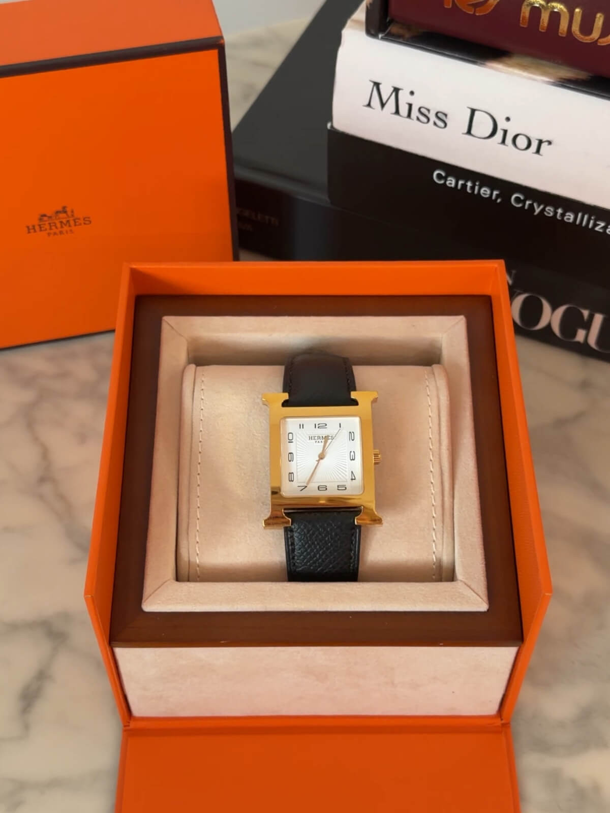 Louise Row featuring Hermes Heure H Watch gold H and on box and black leather strap