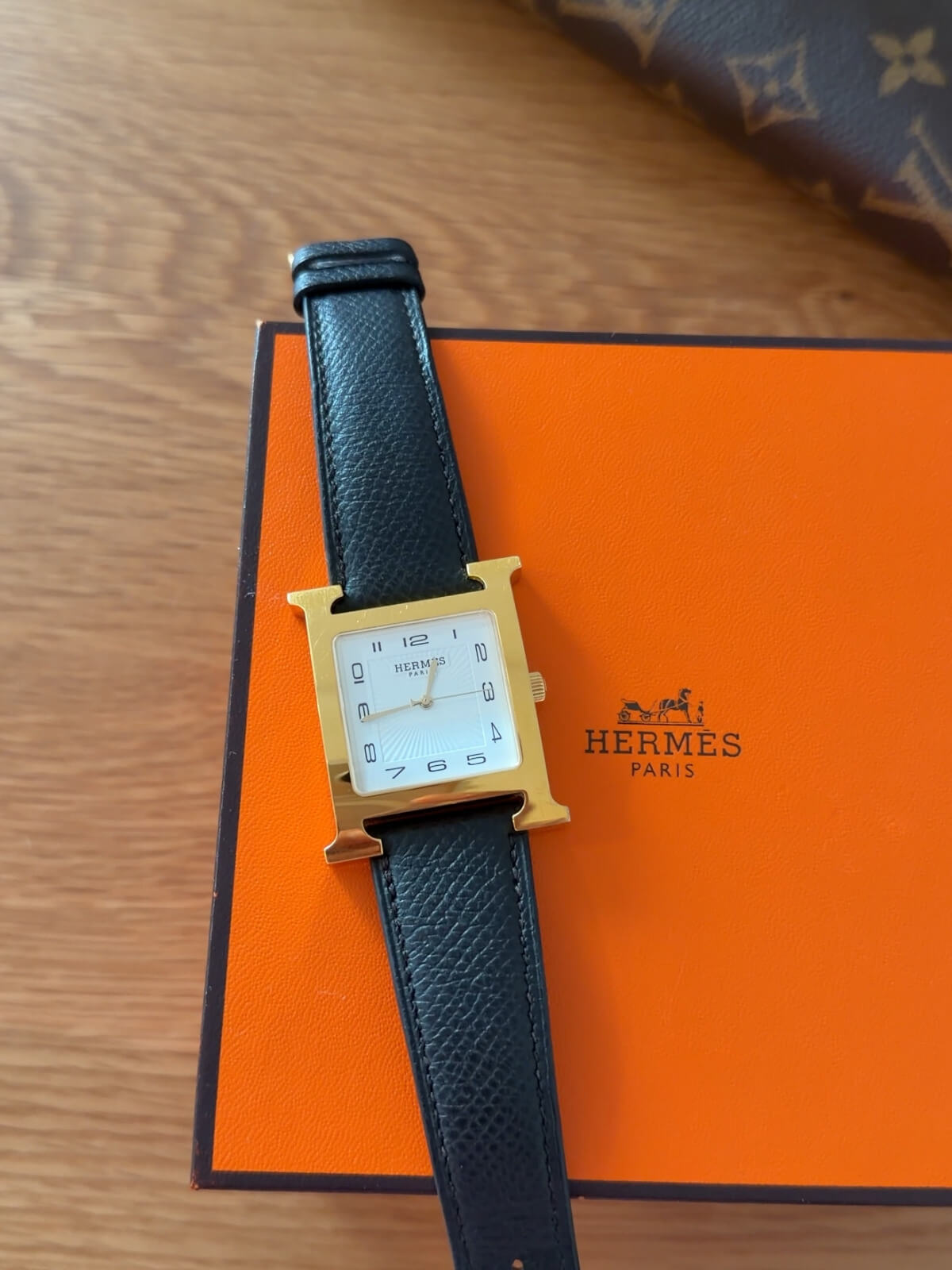 Louise Row featuring Hermes Heure H Watch gold H and on box and black leather strap