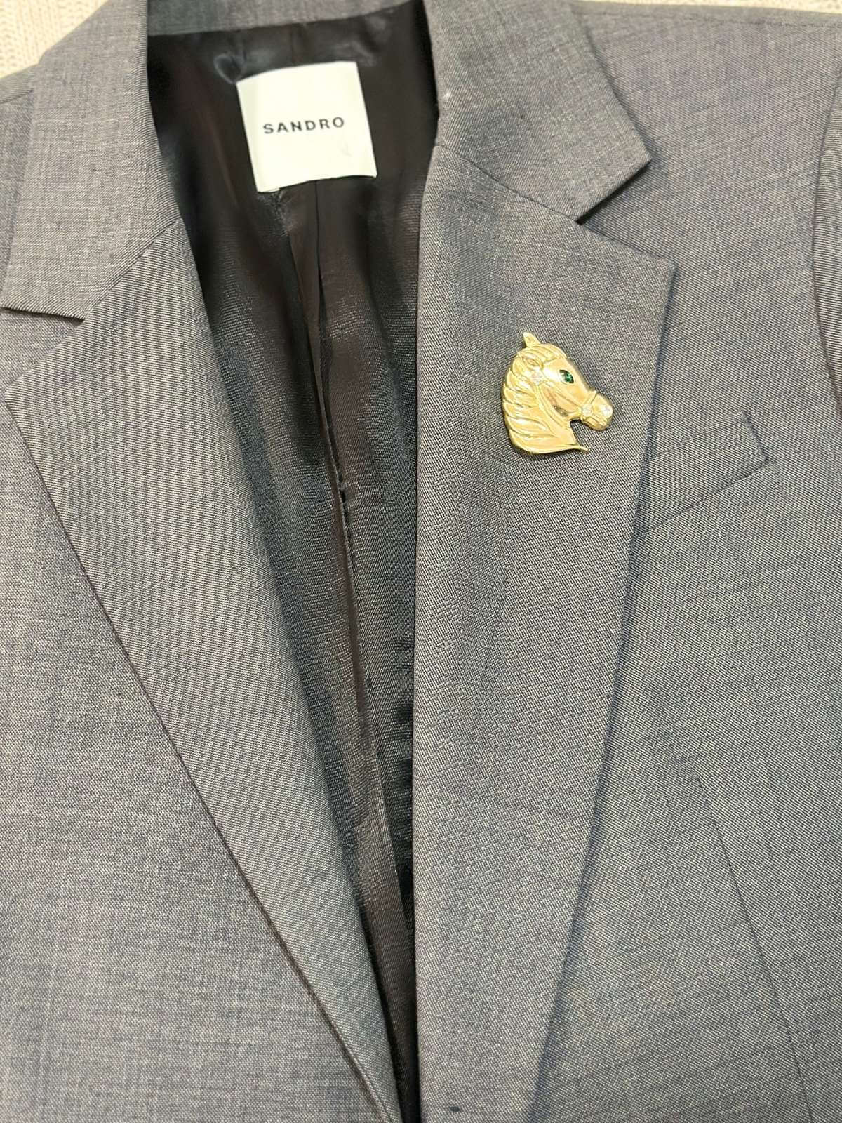 Horse brooch on grey blazer