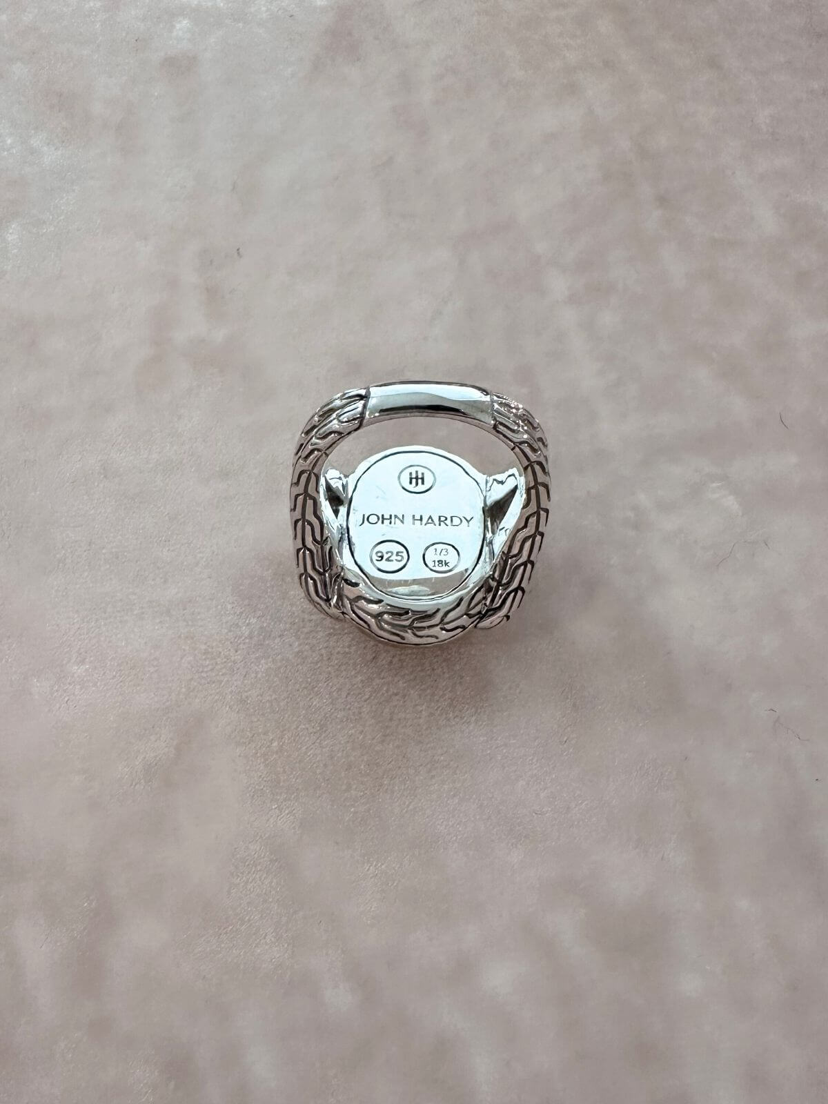 John Hardy ring silver and gold on red fixture back with signature