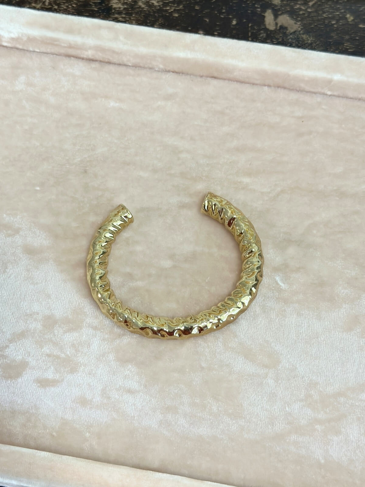 Louise Row featuring Jennifer Fisher Maeve gold hammered cuff on pink pad.