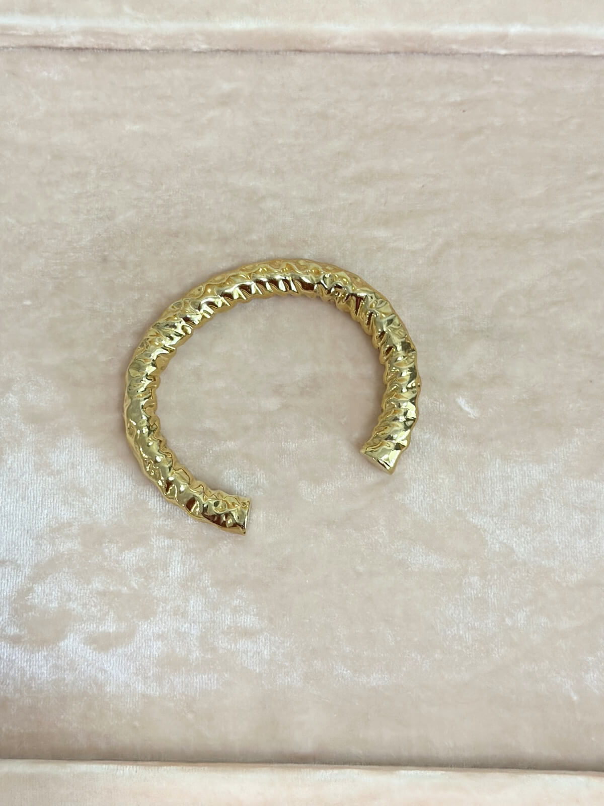 Louise Row featuring Jennifer Fisher Maeve gold hammered cuff on pink pad.