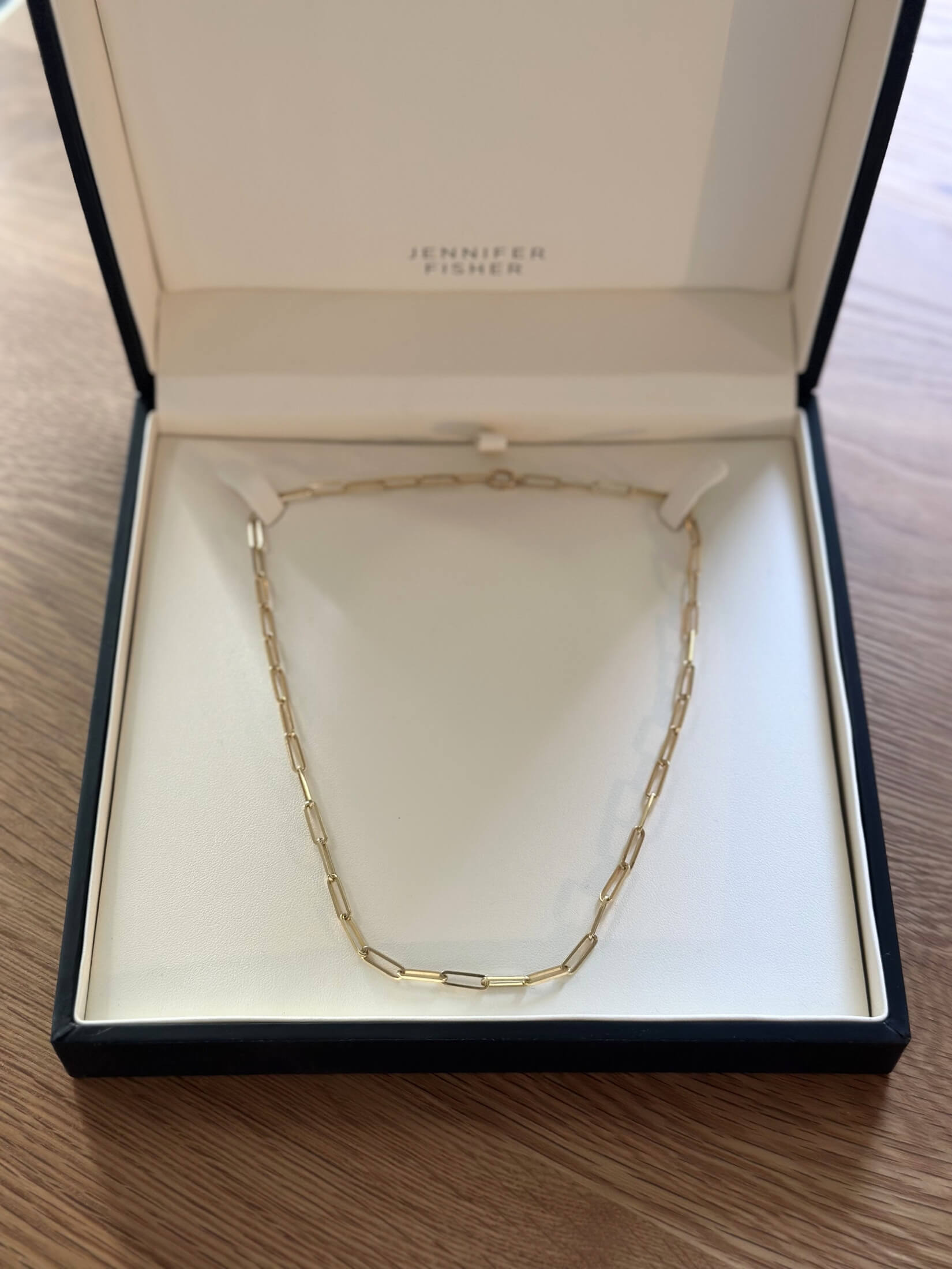 Louise Row featuring Jennifer Fisher gold paperclip necklace in box on table