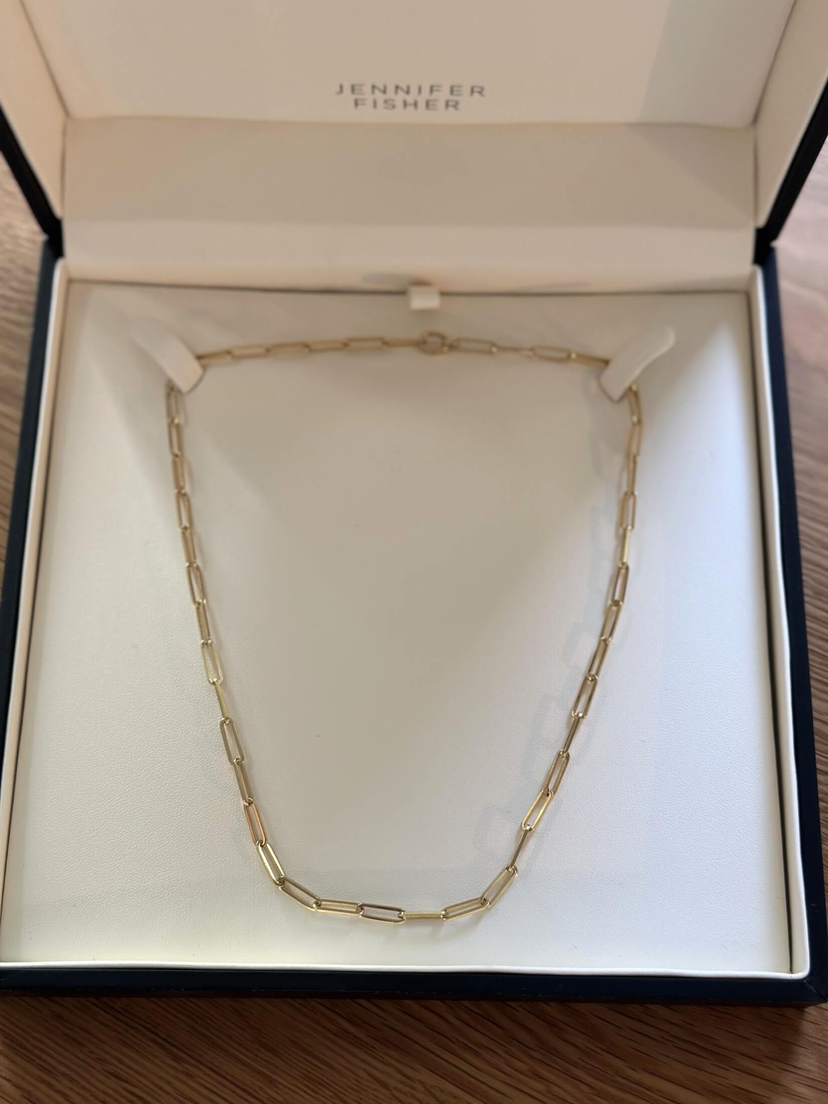 Louise Row featuring Jennifer Fisher gold paperclip necklace in box on table