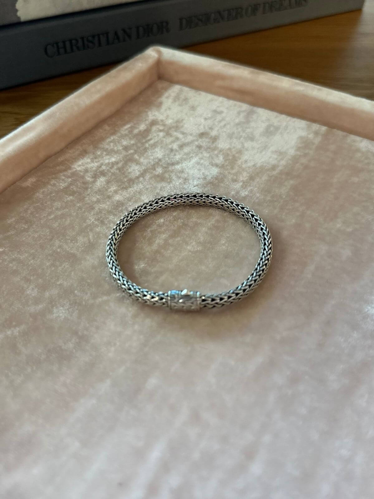 John Hardy Silver bracelet on pink display