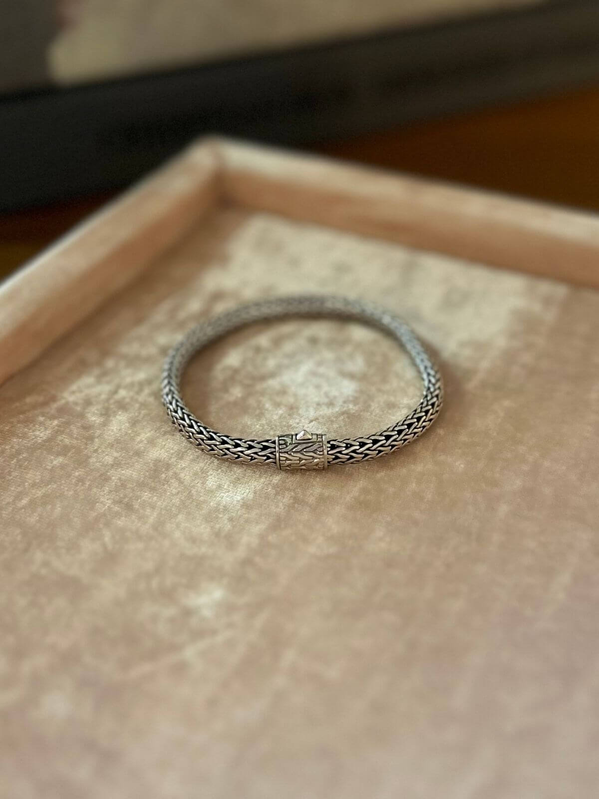 John Hardy Silver bracelet on pink display