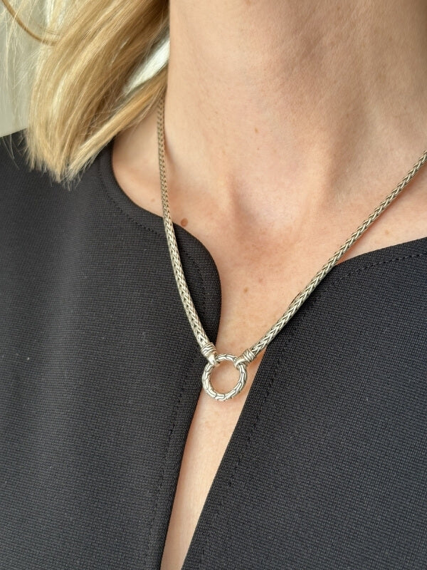 Louise Row Studio featuring John Hardy amulet silver chain on model close up of neck with black top.