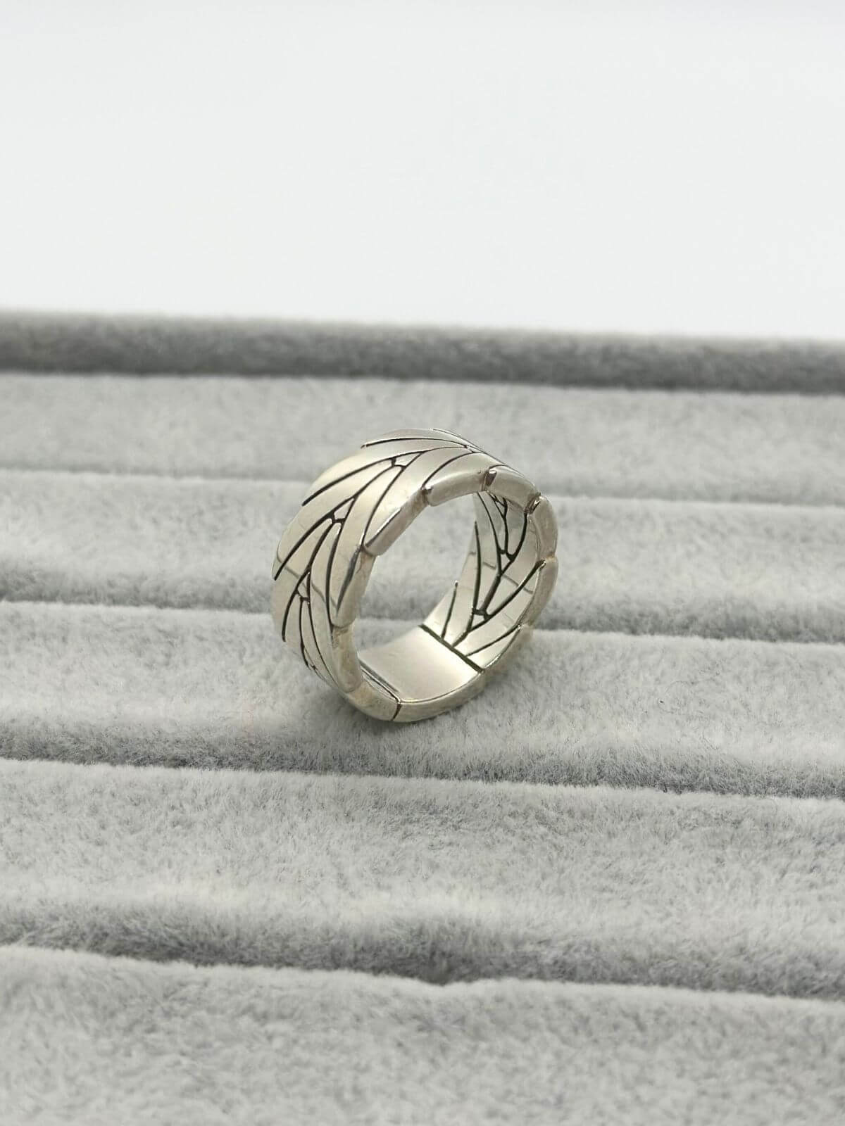 John Hardy silver ring (band) on grey fixture. With chevron design.