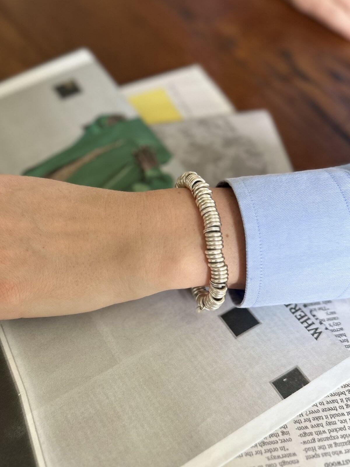 Silver bracelet on a wrist with a blurred background