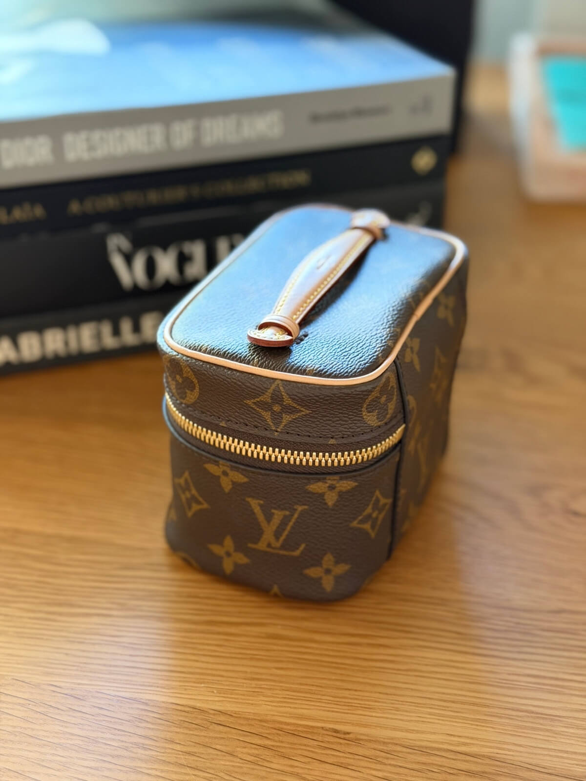 Louise Row featuring Louis Vuitton Nice Nano Vanity case on table with books