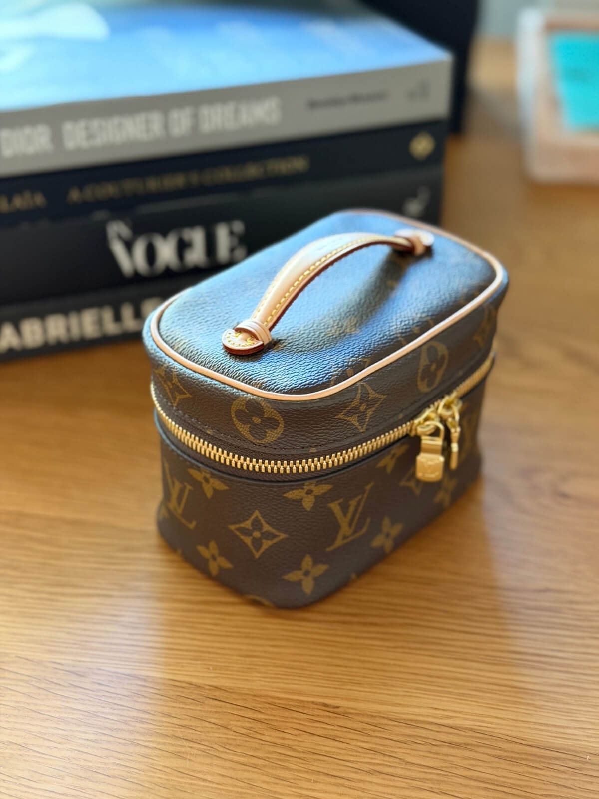 Louise Row featuring Louis Vuitton Nice Nano Vanity case on table with books