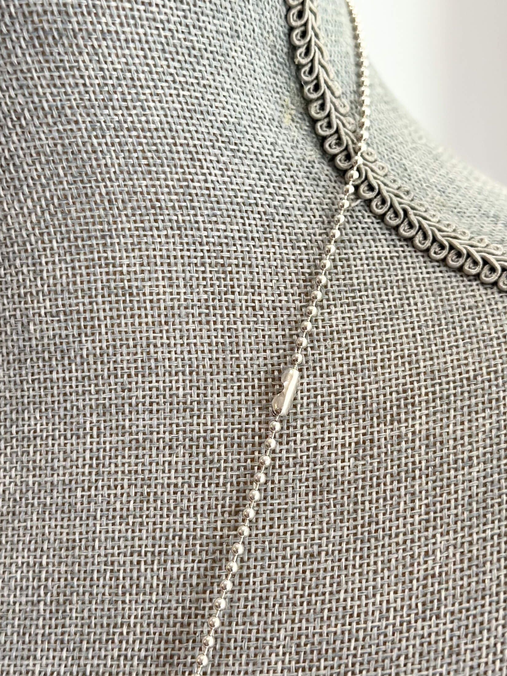 Louise Row featuring silver Lago Sun necklace on grey mannequin