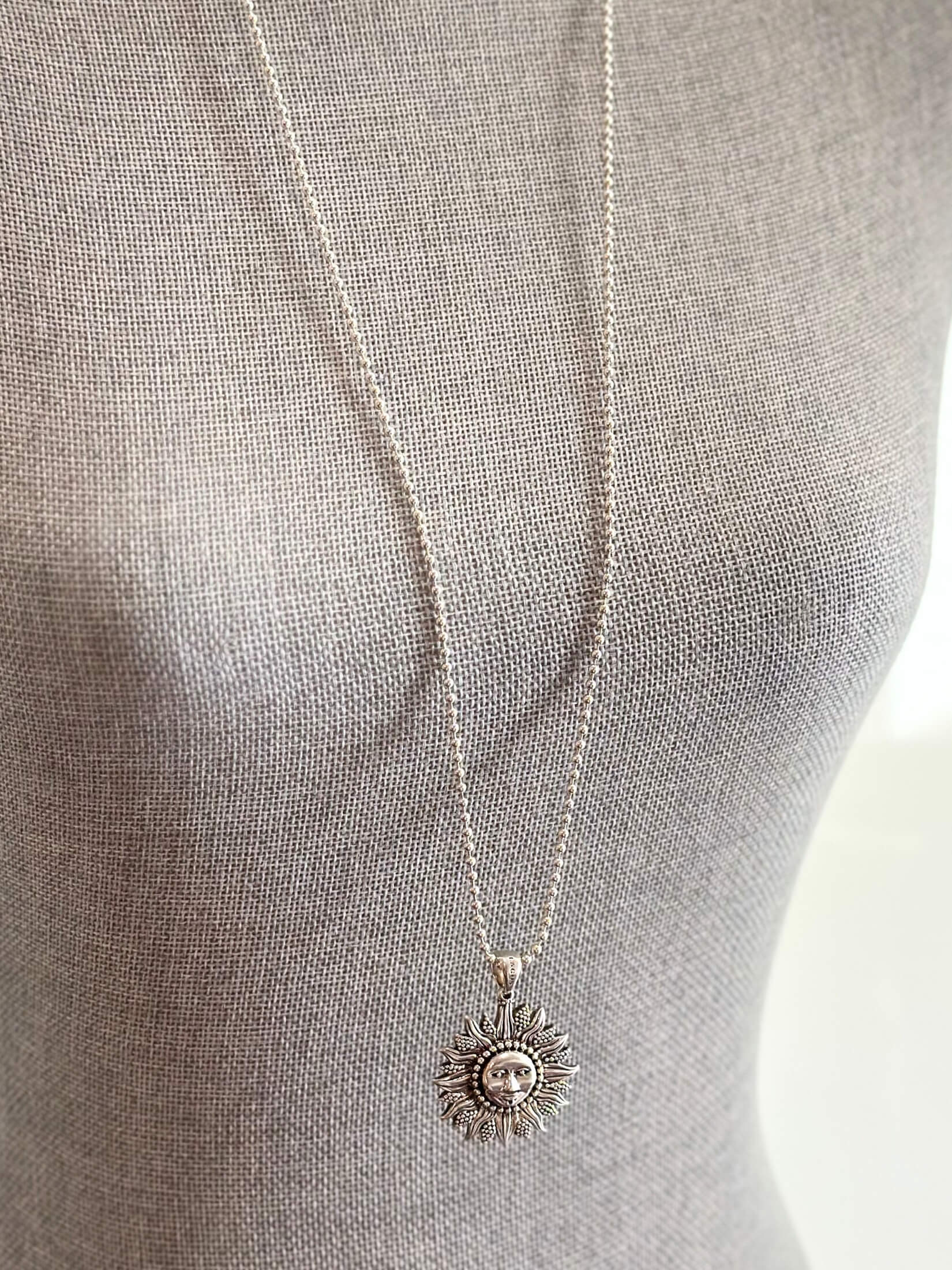 Louise Row featuring silver Lago Sun necklace on grey mannequin